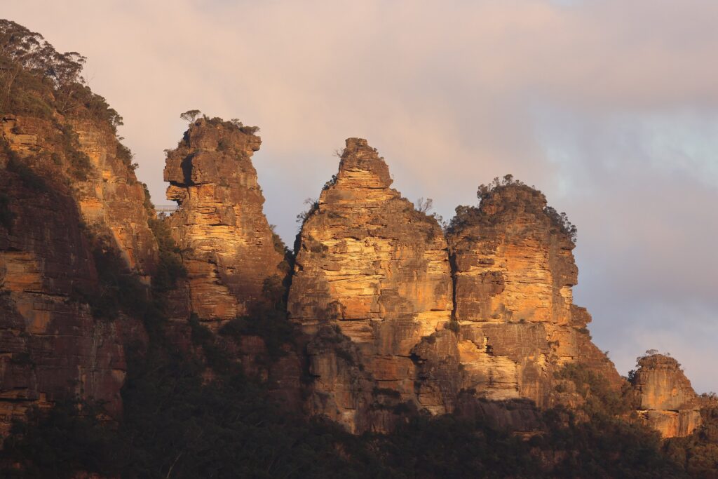 夕阳将蓝山三姐妹峰的砂岩岩柱染成暖金色